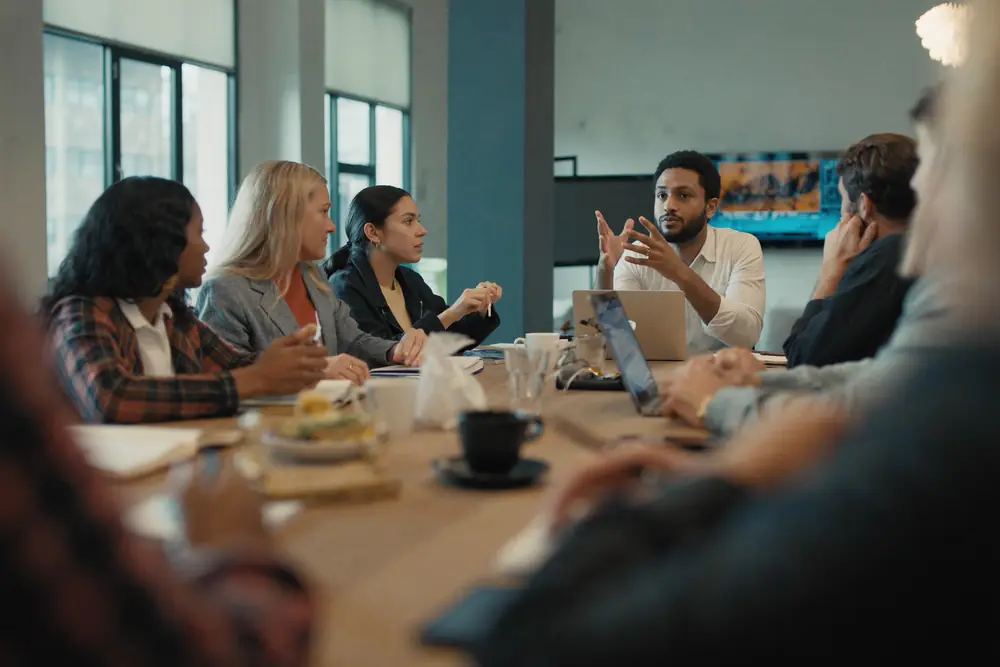 Business owners talking around a table with notebooks and coffee
